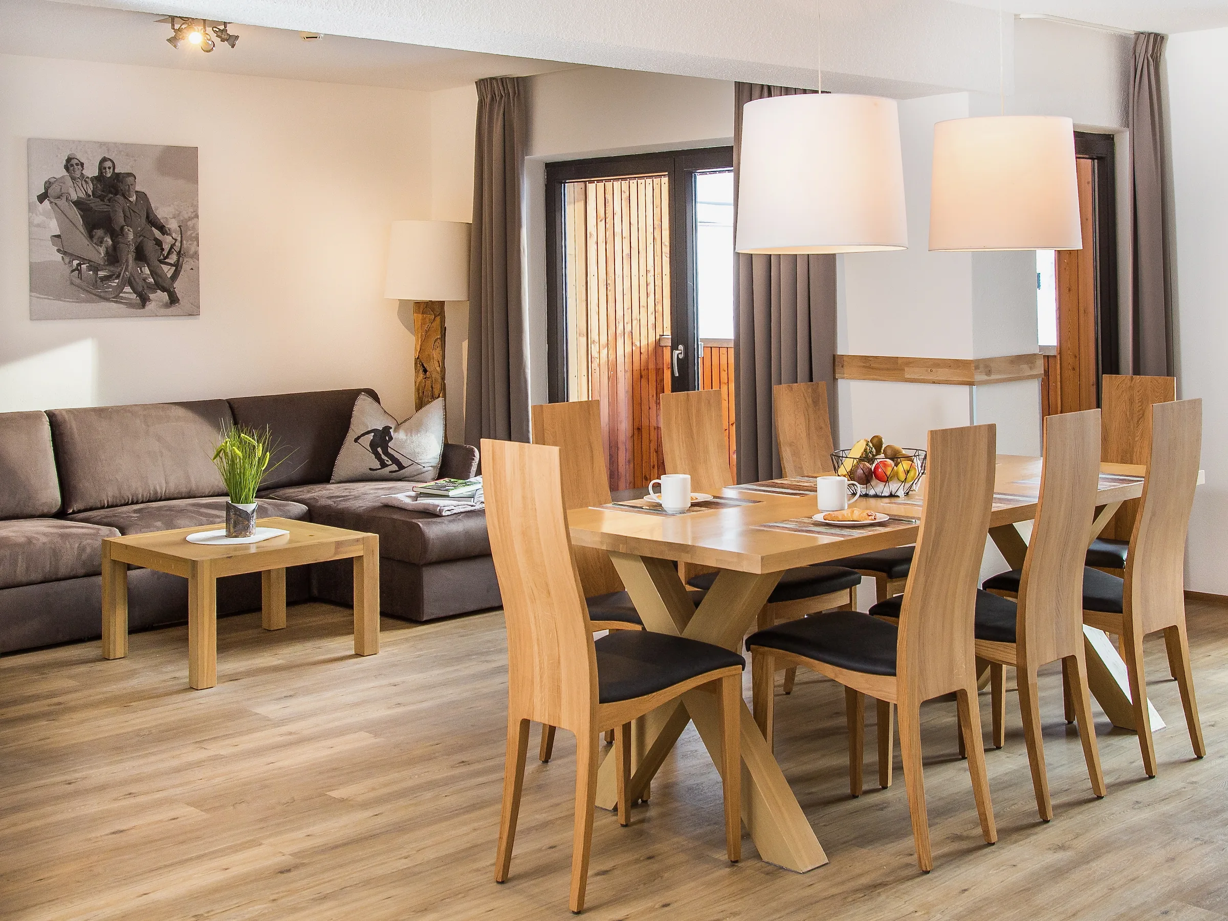 Heller Wohn- und Essbereich mit Holzmöbeln in einem Gastauer Apartment